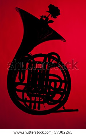 A French horn silhouette with a flower isolated against a red background.