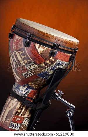 An African or Latin djembe drum isolated against a spotlight gold background.