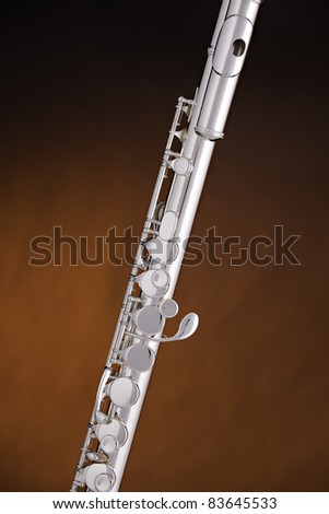 A silver alto flute music instrument on a spotlight gold background with copy space.