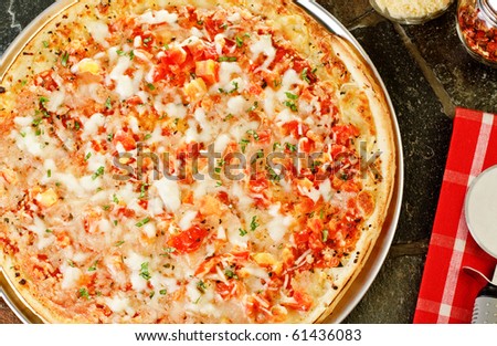 Whole Frozen pizza with cutter and napkin