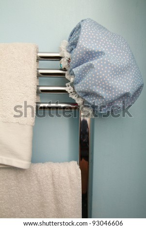 Blue bath hat on chrome radiator with white towels