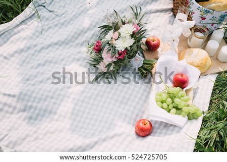 the bride\'s bouquet and fruit lying on the picnic blanket