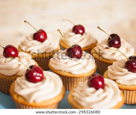 vanilla cupcakes with butter cream frosting and a cherry on top