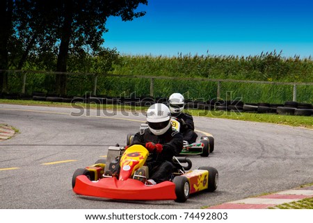 Two people competetively racing with go-karts