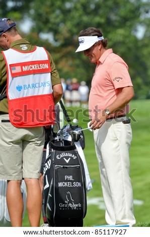 EDISON,NJ-AUGUST 24:Golfer Phil Mickelson talks to  his caddie while he bounces his golf ball on his club during the Barclays pro-am held at the Plainfield Country Club on August 24,2011 in Edison,NJ.