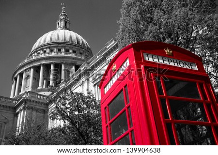 A red London phone box with a black and white St Paul\'s Cathedral in the background