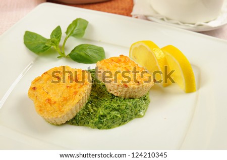 Fishcakes with lemon, basil leaves and green sauce in a restaurant