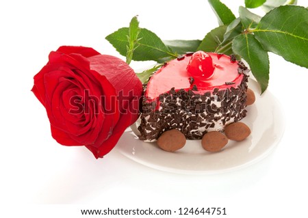 Pink rose and cake isolated on white