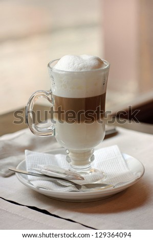 Latte coffee cocktail in a cafe with spoon and napkin