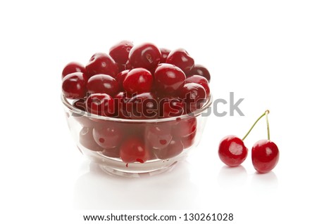 Heap of sweet cherries in glass ware, isolated on white