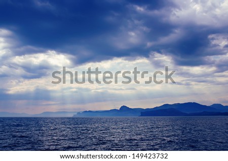 Dramatic deep blue and black  sea with sun rays