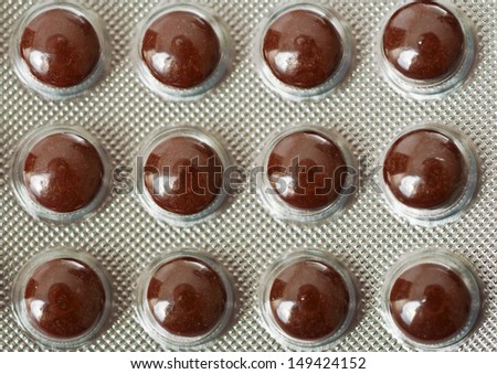 Package with brown vitamin tablets macro background
