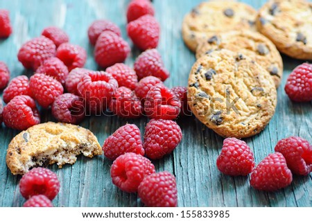 Fresh raspberry on the blue wooden rustic desk with cookies
