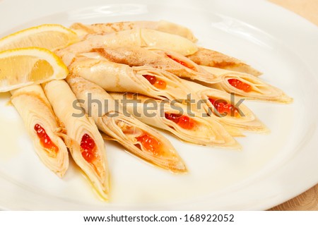 Pancakes with red caviar - traditional russian dish in restaurant