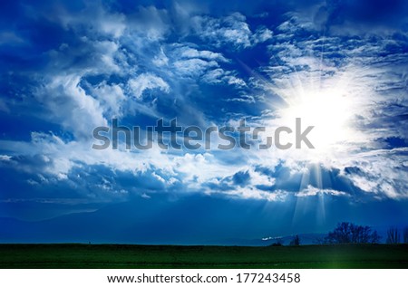 Dramatic clouds with sun on the blue sky on the sunset