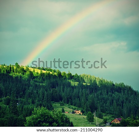 Mountain landscape with green hill and the rainbow, vintage retro background