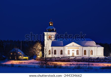 Swedish church building, illuminated at night with deep blue sky