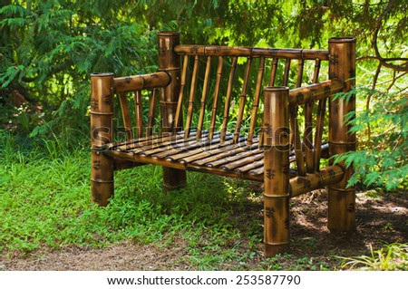 Bamboo bench in a green summer forest, sunny landscape background