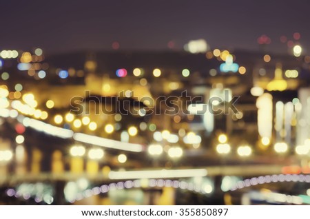 Night view of famous european Prague city - the capital pf Czech republic with reflection in river Vltava and historical bridges - blurred defocused background