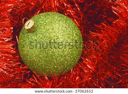 Christmas holiday decor with green sphere and red tinsel