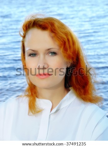 Romantic young woman with red hair, on the blue water background
