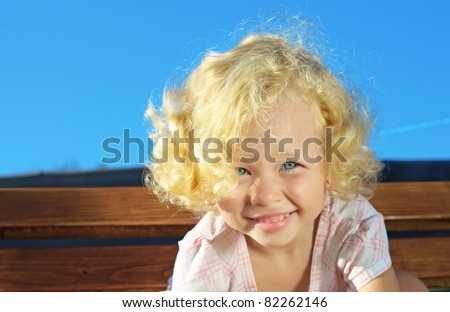 Outdoor shoot of little funny blonde curly girl