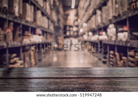 Empty dark wood table top on blurred warehouse background for  display your products.