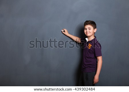 student boy  beside a big blackboard for drawing, writing and show the place for your text,