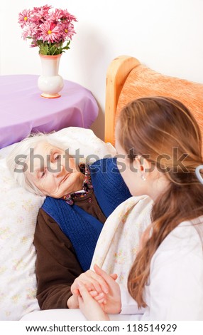 Young doctor holds the old woman's hands
