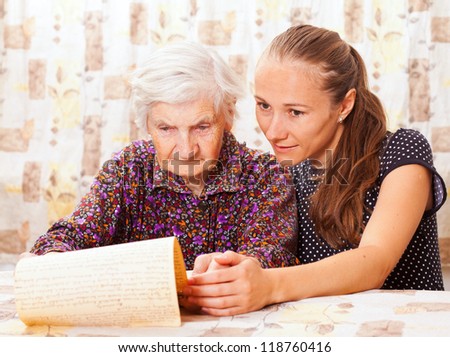 Young sweet lady holds the elderly woman's hand