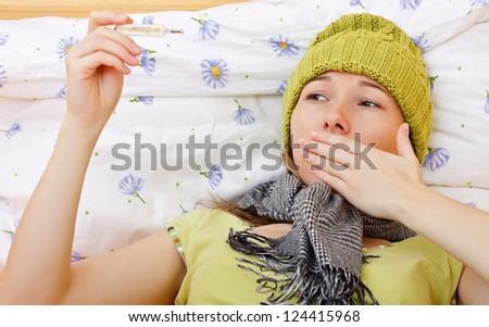 Young sick woman laying on bed having high fever