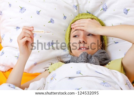 Young girl laying on the bed and feeling bad because the high fever