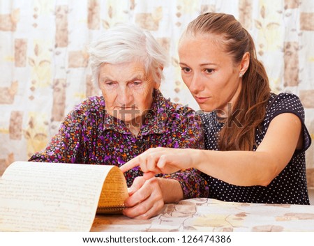 Young sweet lady holds the elderly woman\'s hand