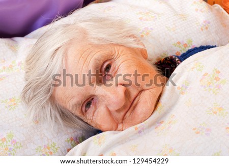 Elderly lonely woman in the bed