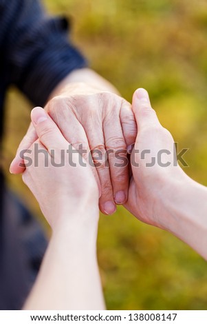 Young doctor hold elderly hands
