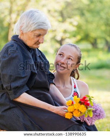 Elderly woman get flowers from her grandchild