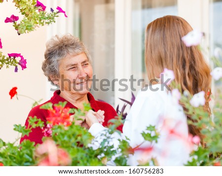 Happy elderly woman and her helpful assistant