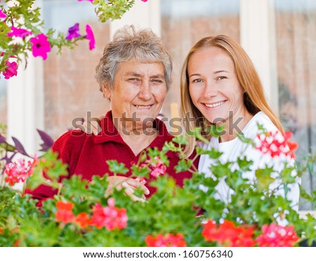 Happy elderly woman and her helpful assistant