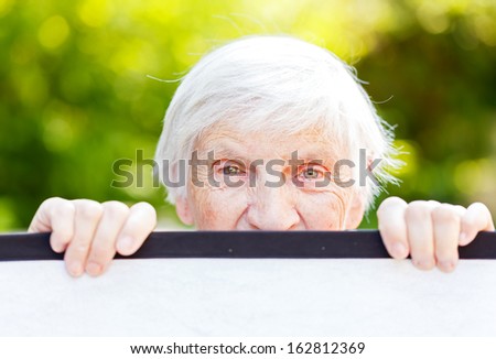 Portrait of the smiling elderly woman on outdoors