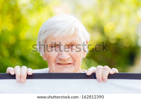 Portrait of the smiling elderly woman on outdoors