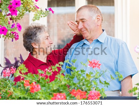 The happy elderly woman caresses her hausband