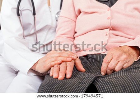 Young doctor giving helping hands for elderly woman