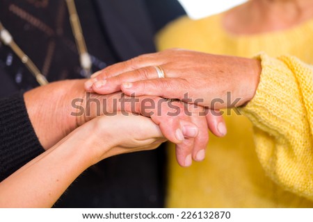 Young doctor holds the old women hands