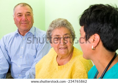 Photo of happy elderly couple with the doctor