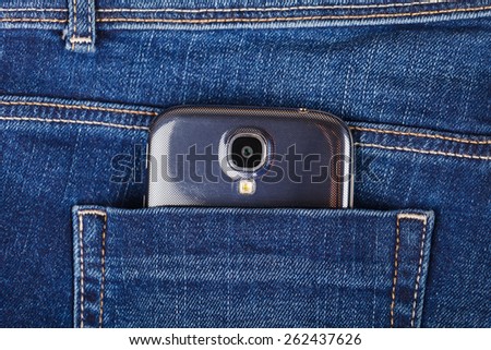 Mobile phone in the pocket of blue jeans