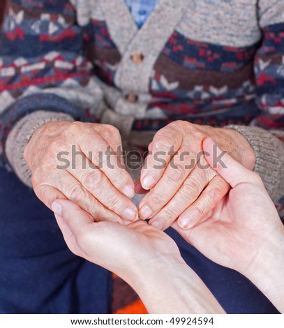Young doctor holds the old man\'s hand