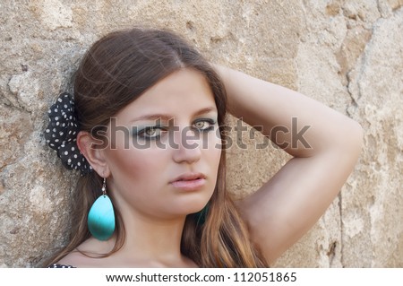 Beautiful woman, supported by a wall portrait
