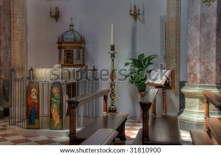 Interior corner of Italian church with font, lectern and large candle