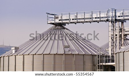 Detail of top of grain store with background hill and telecommunications masts