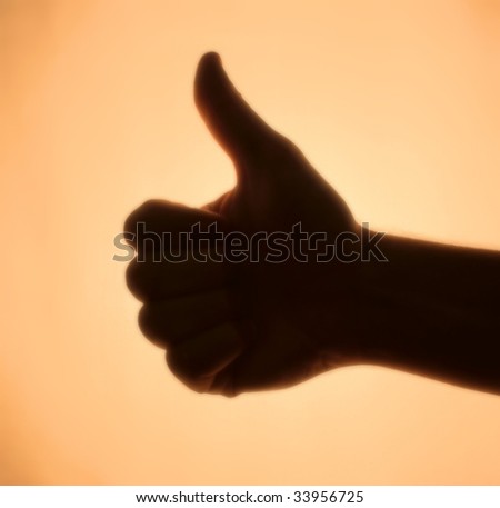 Back-lit hand signaling \'thumbs-up\'